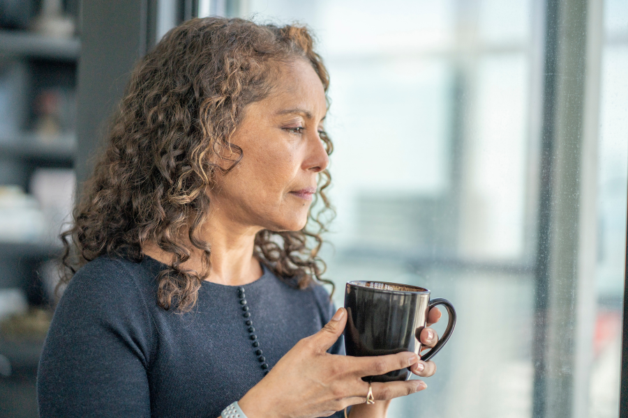 Woman holding a mug gazing thoughtfully